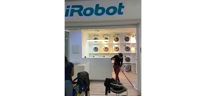 一位清洁工在iRobot Roomba商店里手工拖地